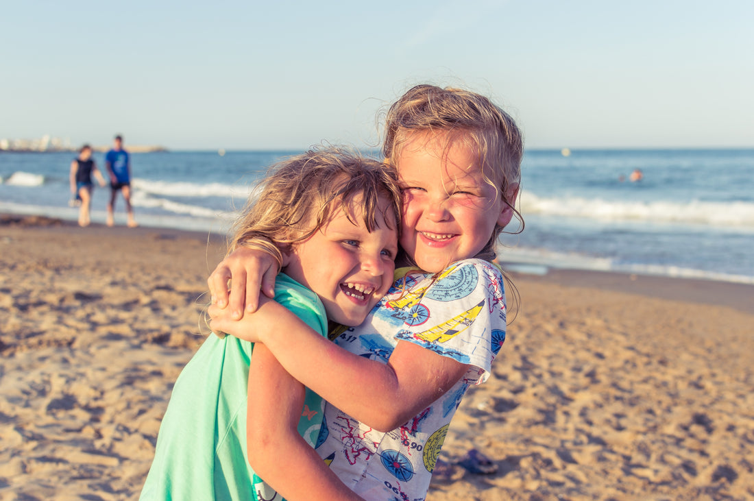 two kids hugging on the beach