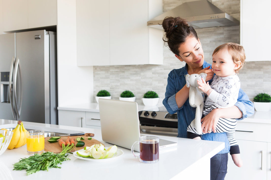 woman holding her child in the kitchen